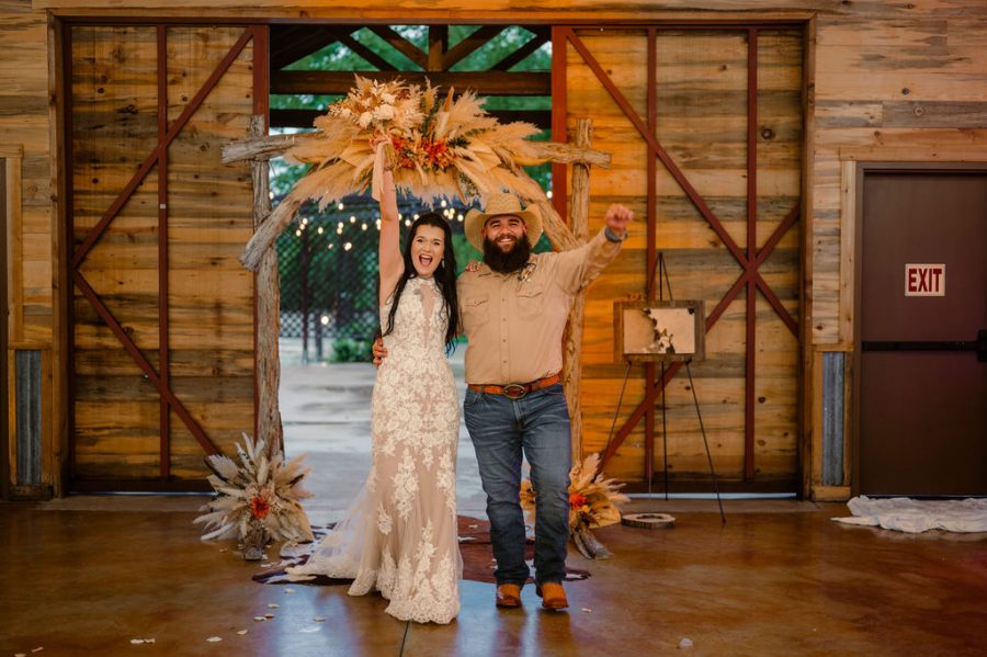 introducing the newlyweds as they celebrate and walk through open barn doors into their reception